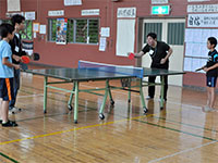 子供達と卓球で遊ぶボランティア参加者